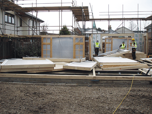 The timber frame panels are moved into position on site