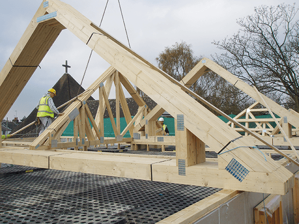 The attic roof trusses are craned into position