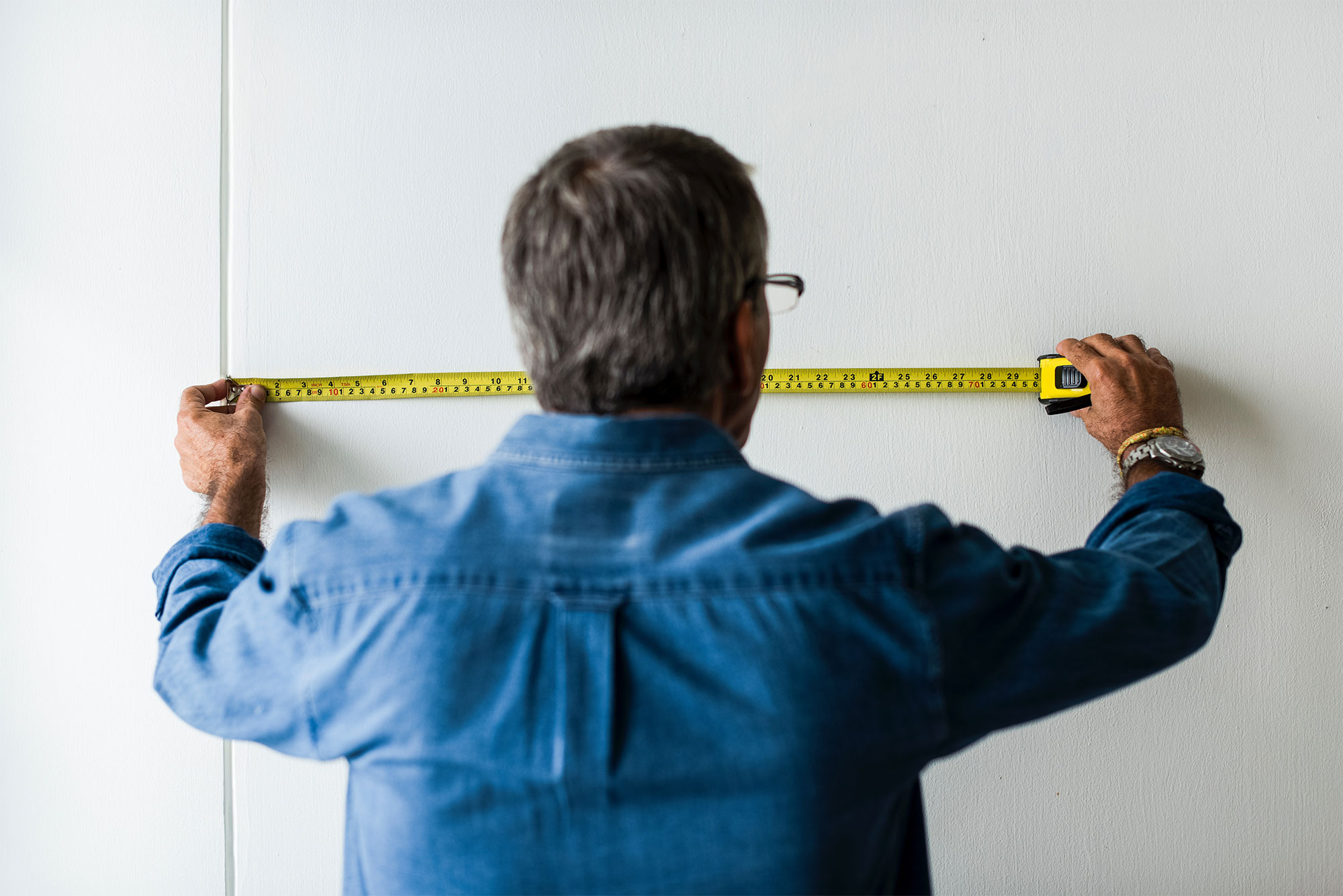 Man measuring wall