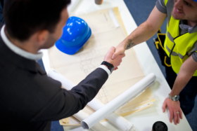 Tradesman and business man shaking hands