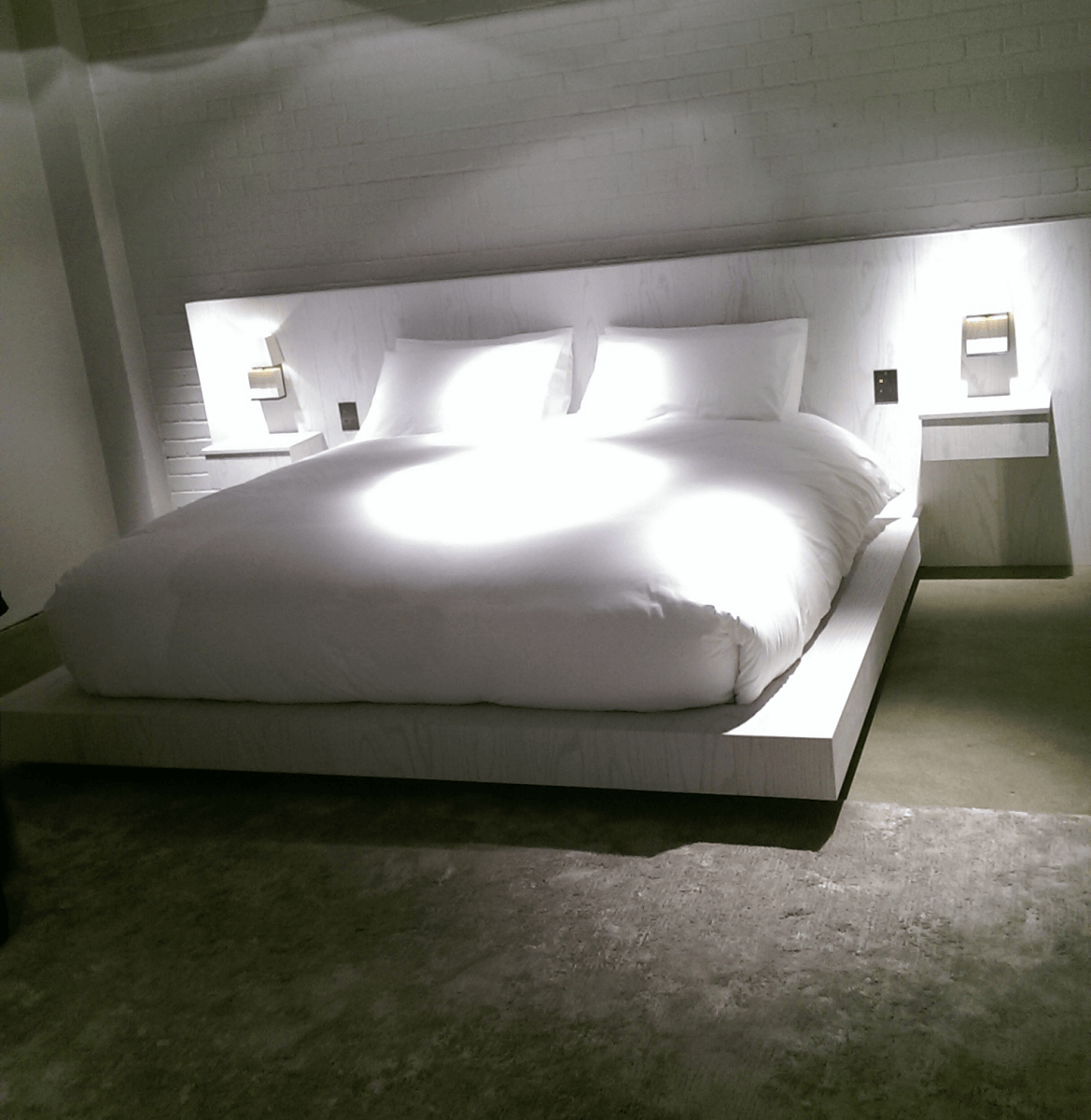 Low bed with integrated bedside lamps