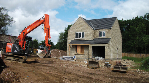 digger next to new build house
