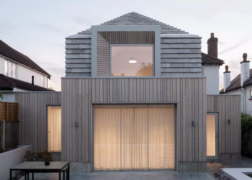 Contemporary home combining cladding with grey roof tiles 