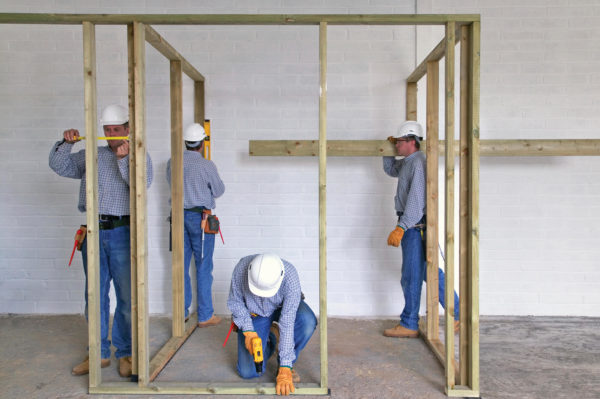 builders working on stud wall