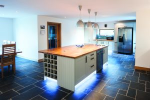 Bright kitchen area with black stone floor