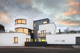 Art deco coastal home with white render and zinc cladding