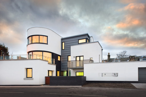 Art deco coastal home with white render and zinc cladding