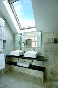 Double sink bathroom with stone tiles