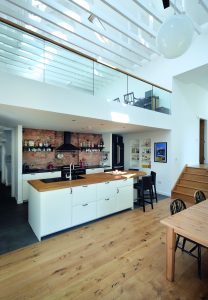 Open plan kitchen with wooden surfaces and floor