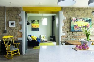Add flair to your barn conversion by highlighting structural features - as with these steel beams, painted yellow to contrast the exposed stone. Photo: Colin Poole