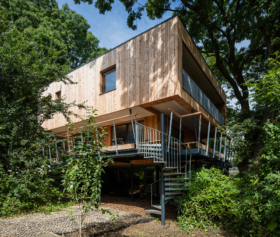 Timber frame tree house set in a wooded landscape