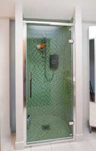 Walk in shower with green tiles