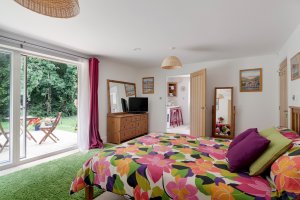 Colourful bedroom scheme with glass sliding doors to a patio