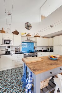 Kitchen with island and blue splashback