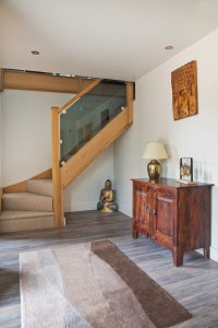 Hallway with wooden staircase and glass balustrade