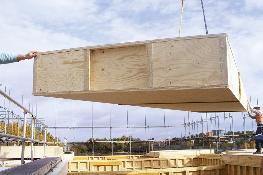 An offsite-manufactured timber floor cassette being craned into position
