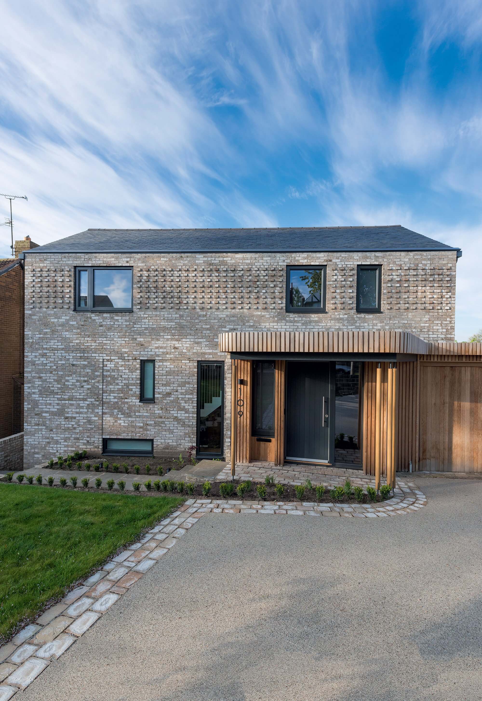 Grey brick detached home with slate roof