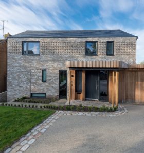 Grey brick detached home with slate roof