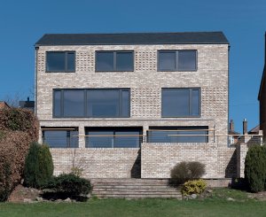 Grey brick detached home with slate roof