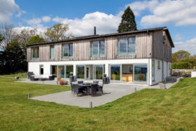 Wood-clad package home with timber frame