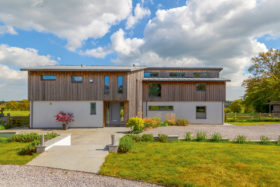 Wood-clad package home with timber frame