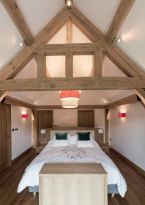 Bedroom with vaulted ceiling with exposed oak beams