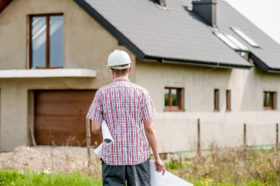 Builder looking at house