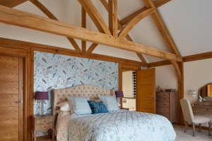 Bedroom in oak frame home with exposed beams