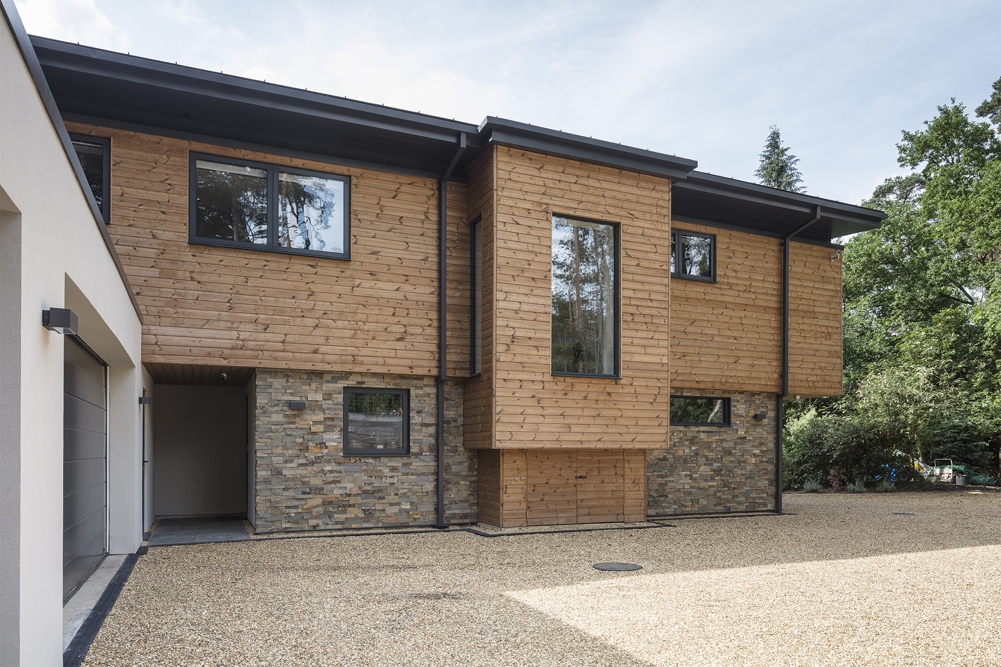 Fully integrated smart home as seen from outside clad in stone and timber