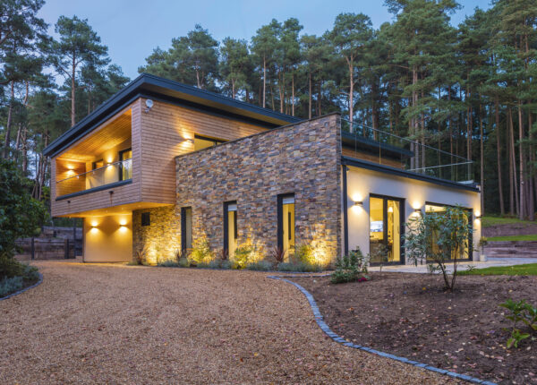 Fully integrated smart home as seen from outside clad in stone and timber