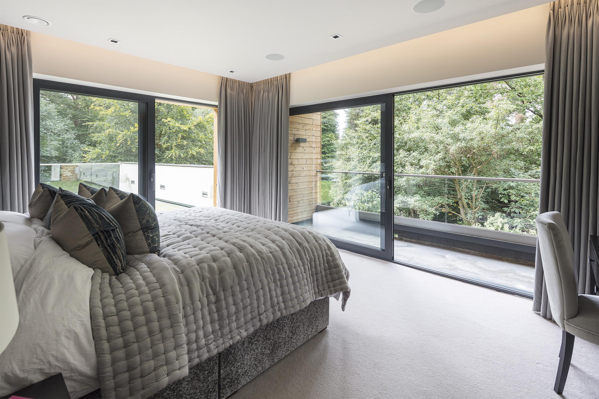 Bedroom with balcony featuring large sliding doors in fully integrated smart home