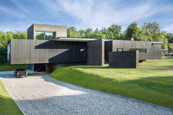 Gravel driveway under black-clad house designed by AR Studio