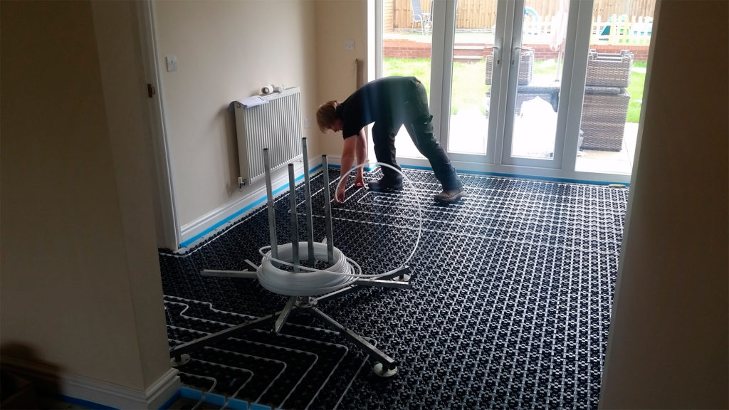 Man fitting underfloor heating system Minitec by Uponor
