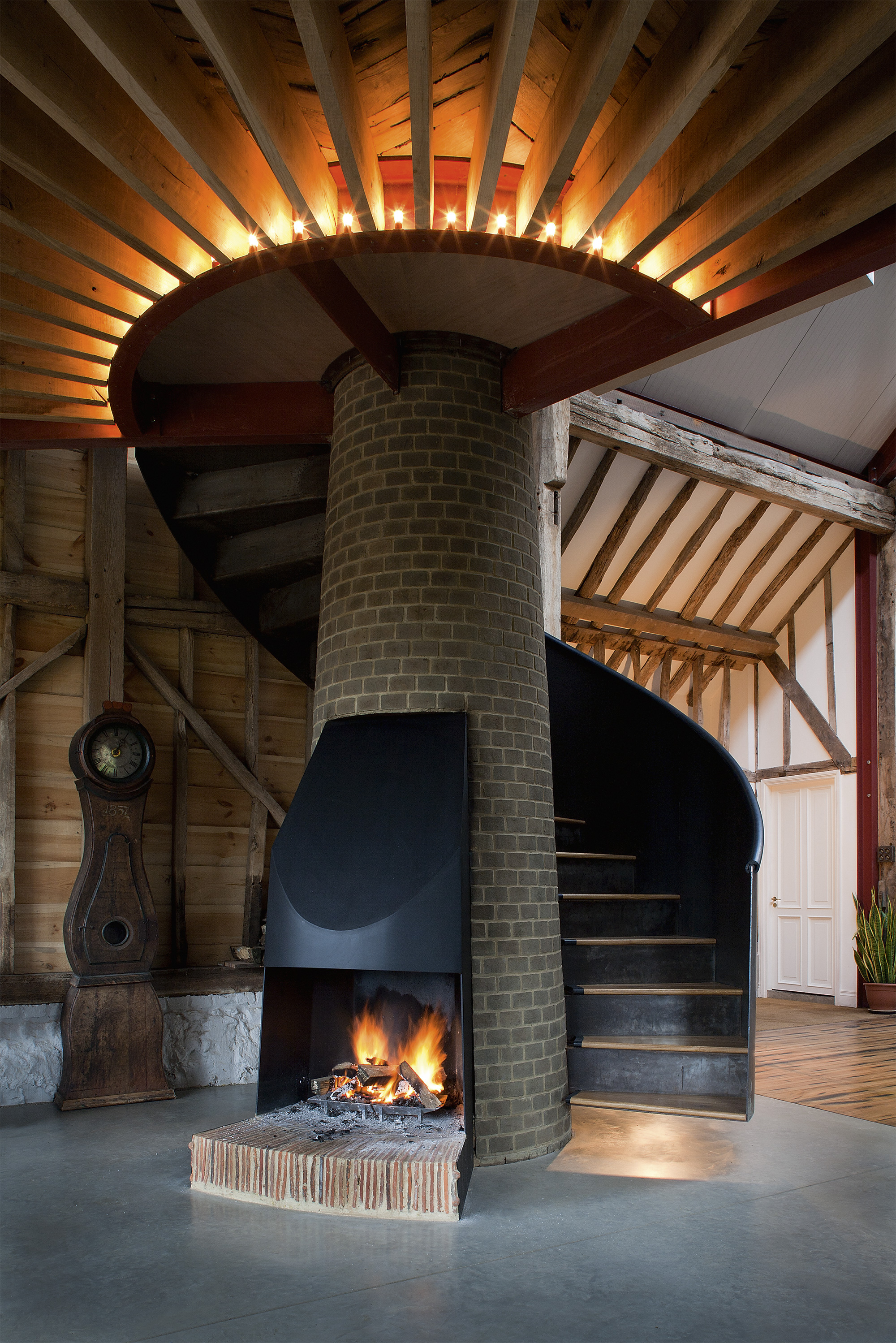 Stairs wrapped around chimney in barn conversion by Liddicoat & Goldhill