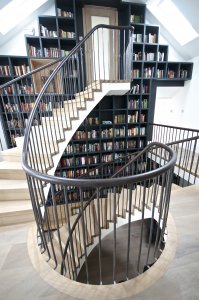 Multi-flight helical staircase featuring oak threads and risers with steel balustrades