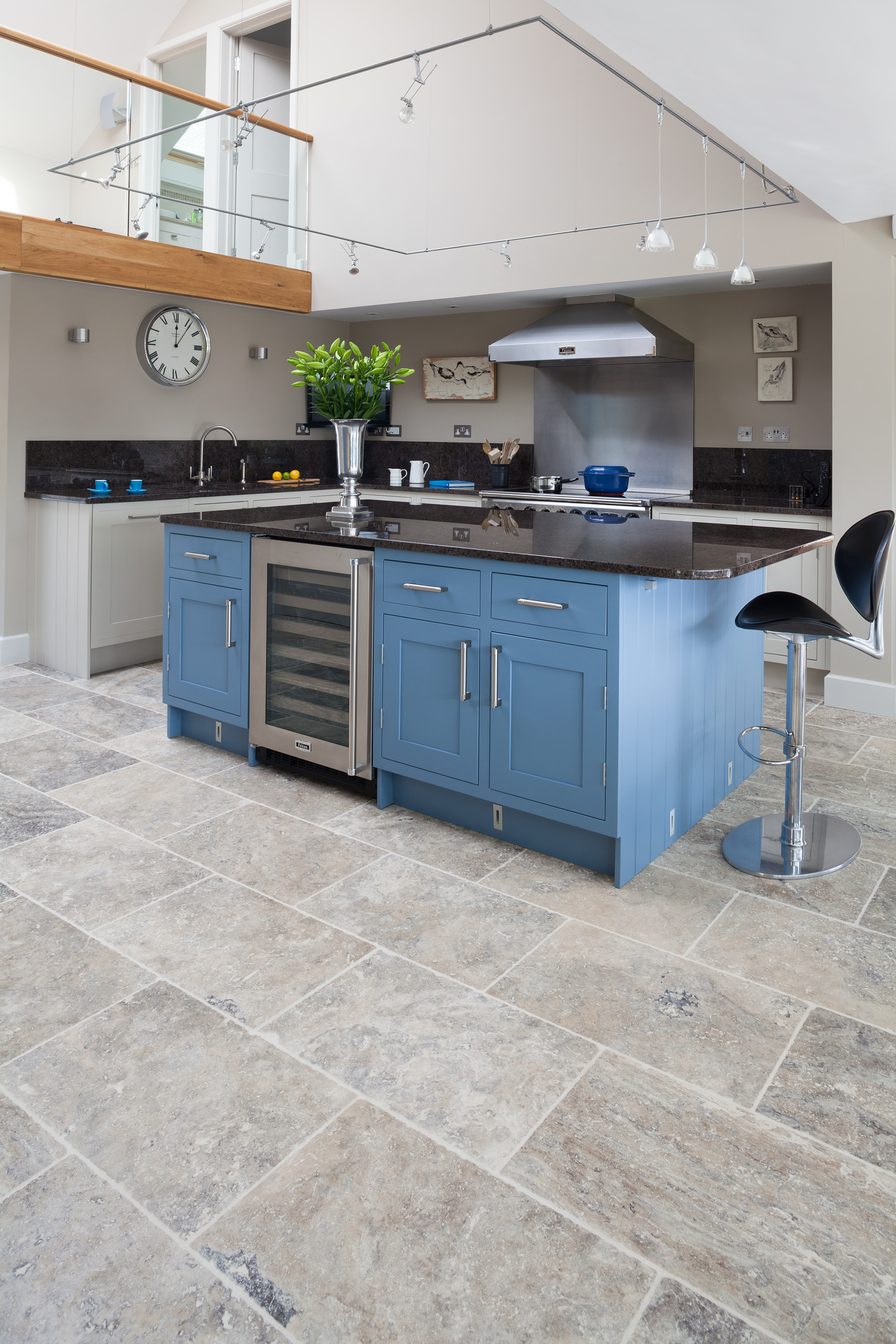 Blue kitchen cabinets and stone flooring