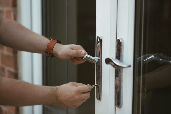 Close up of man locking glazed doors