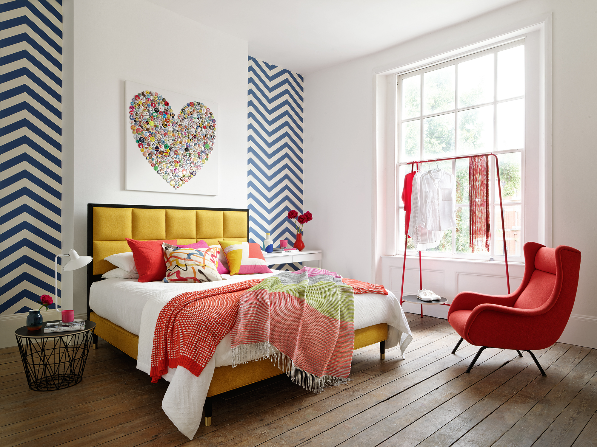 Bedroom with colourful patterns and bed with yellow bedframe