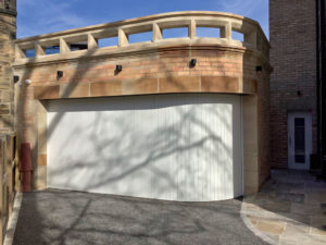 6.6m x 2.3m curved Rundum Meir Original side-sliding garage door, manufactured from extruded aluminium, insulated and powder-coated to the client's spec. Prices start from £8,000