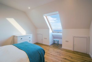 Bedroom with rooflight on vaulted ceiling and eaves storage