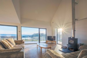 Living room with woodburner and sliding doors and ample glazing on Scotland's Isle of Skye