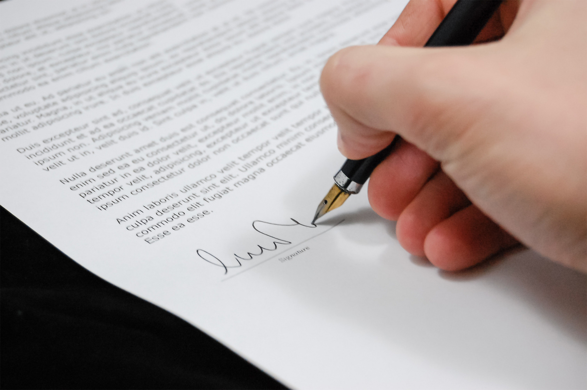 Close up of a man's hand signing a contract