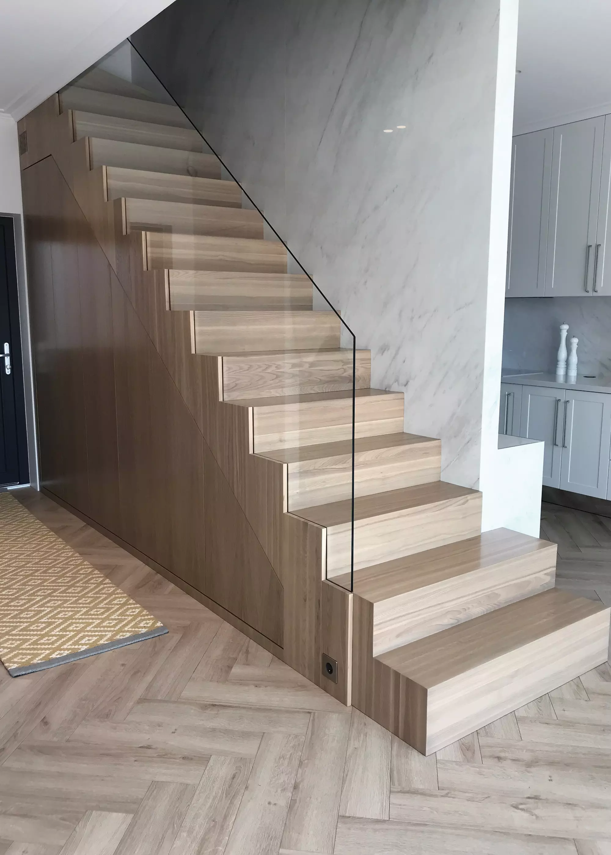 staircase made with light-toned solid ash and glass balustrade
