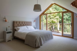 Bedroom with large apex window and balcony