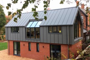 Timber frame clad in brick and zinc