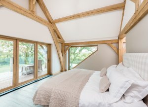 Bedroom in oak frame home with balcony