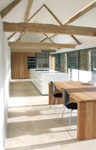 Kitchen in cow byre conversion featuring large expanses of glass
