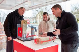 Men watching demonstration of wall insulation