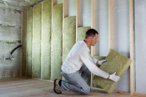 man applying wool to wall