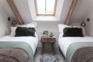 Cosy and contemporary twin bedroom with exposed beams